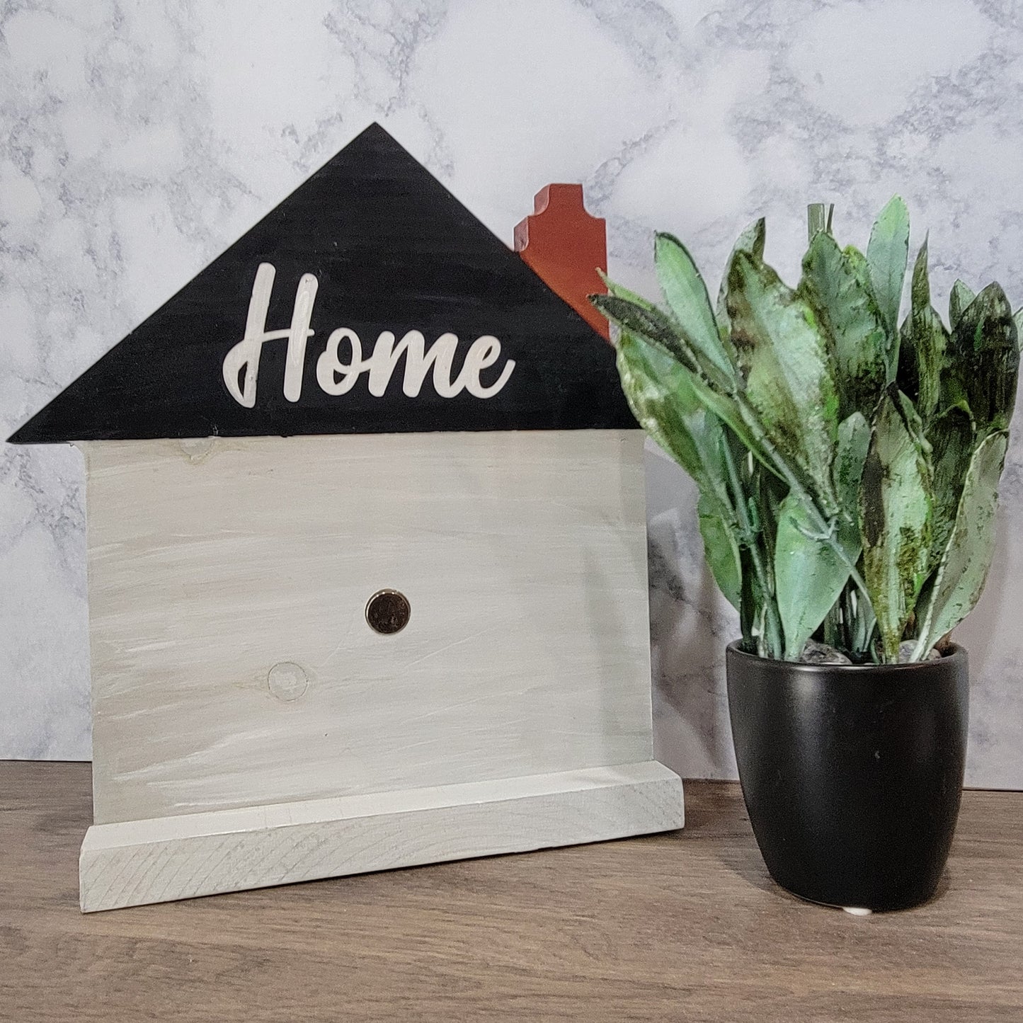 grey house shaped sign with the word home