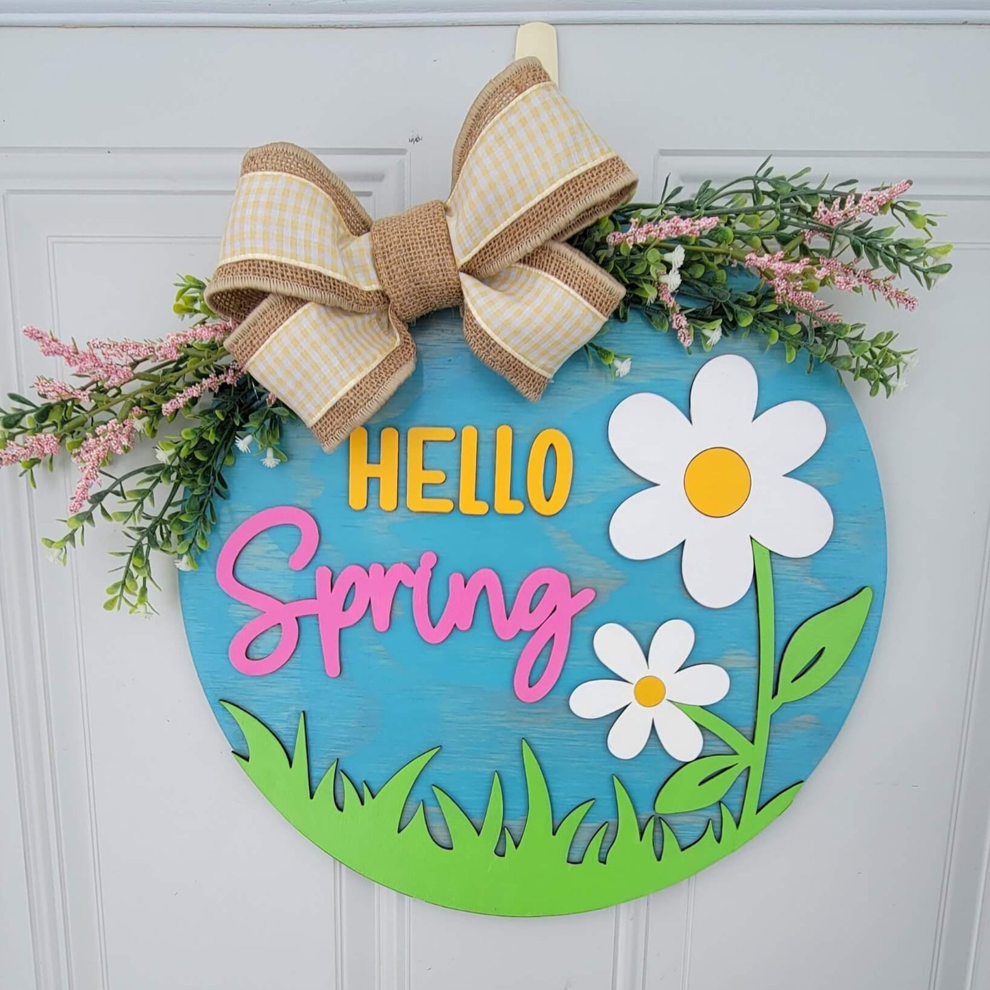 hello spring door hanger with white and yellow flowers with bow and spring greenery front view hanging on door