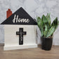 white house shaped sign with word home and faith cross