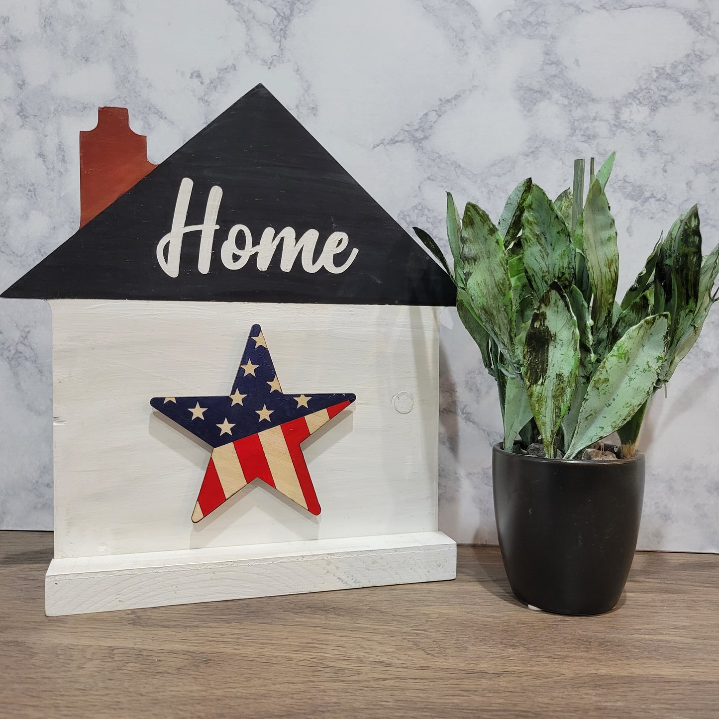 white house shaped sign with word home and patriotic flag star