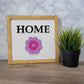 Light wood framed tabletop home sign with purple and pink spring flower