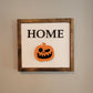 Dark wood framed home sign hanging on wall with halloween jack o lantern