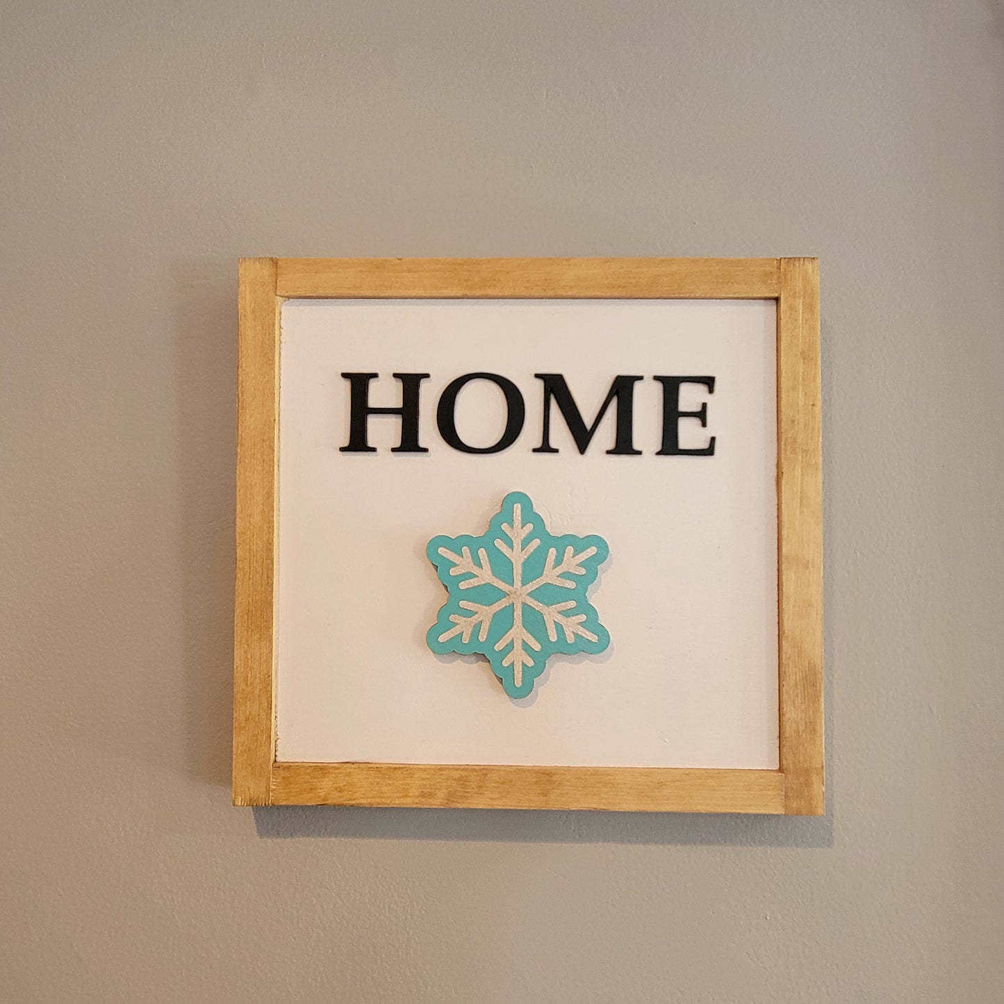 Light wood framed hanging home sign with silver and blue snowflake