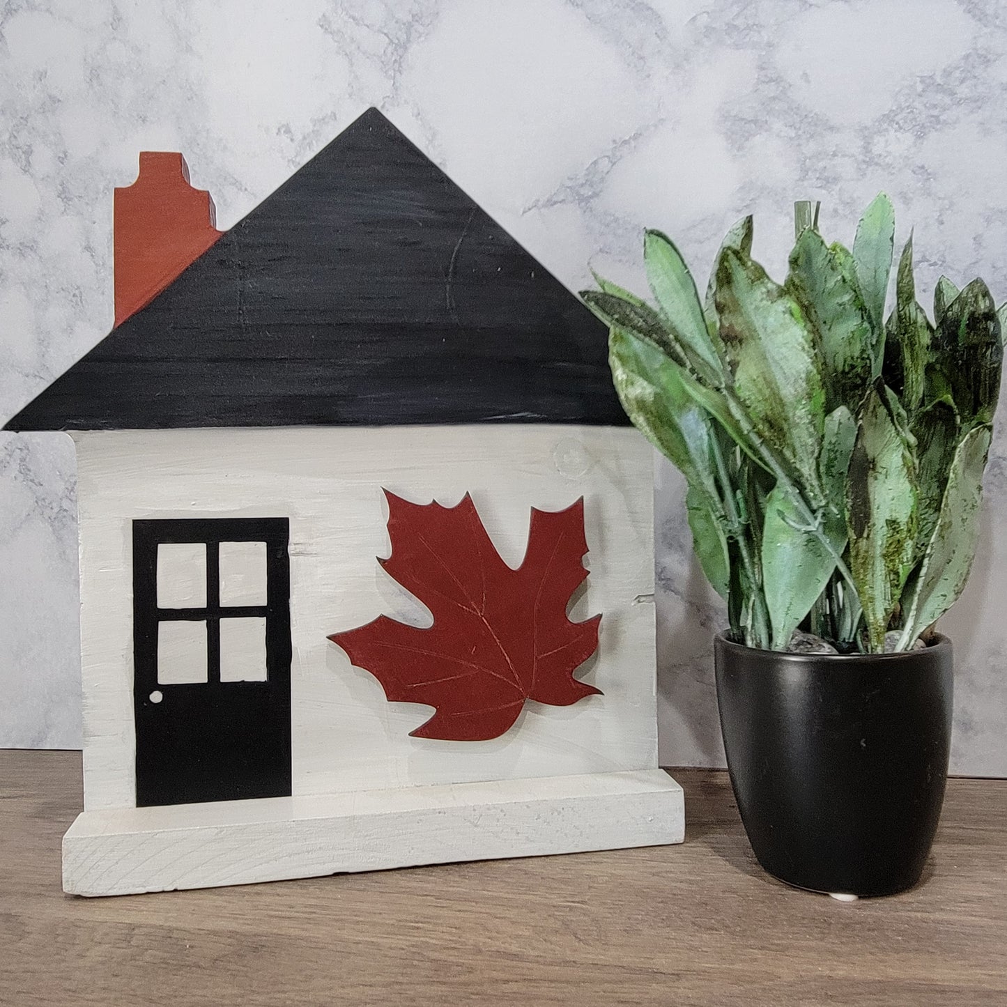 grey house shaped sign with front door and fall maroon leaf