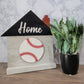 grey house shaped sign with the word home and baseball