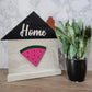 grey house shaped sign with the word home and watermelon