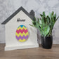 white and grey house shaped wood interchangeable sign with the word home and easter egg