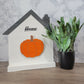 white and grey house shaped wood interchangeable sign with the word home pumpkin