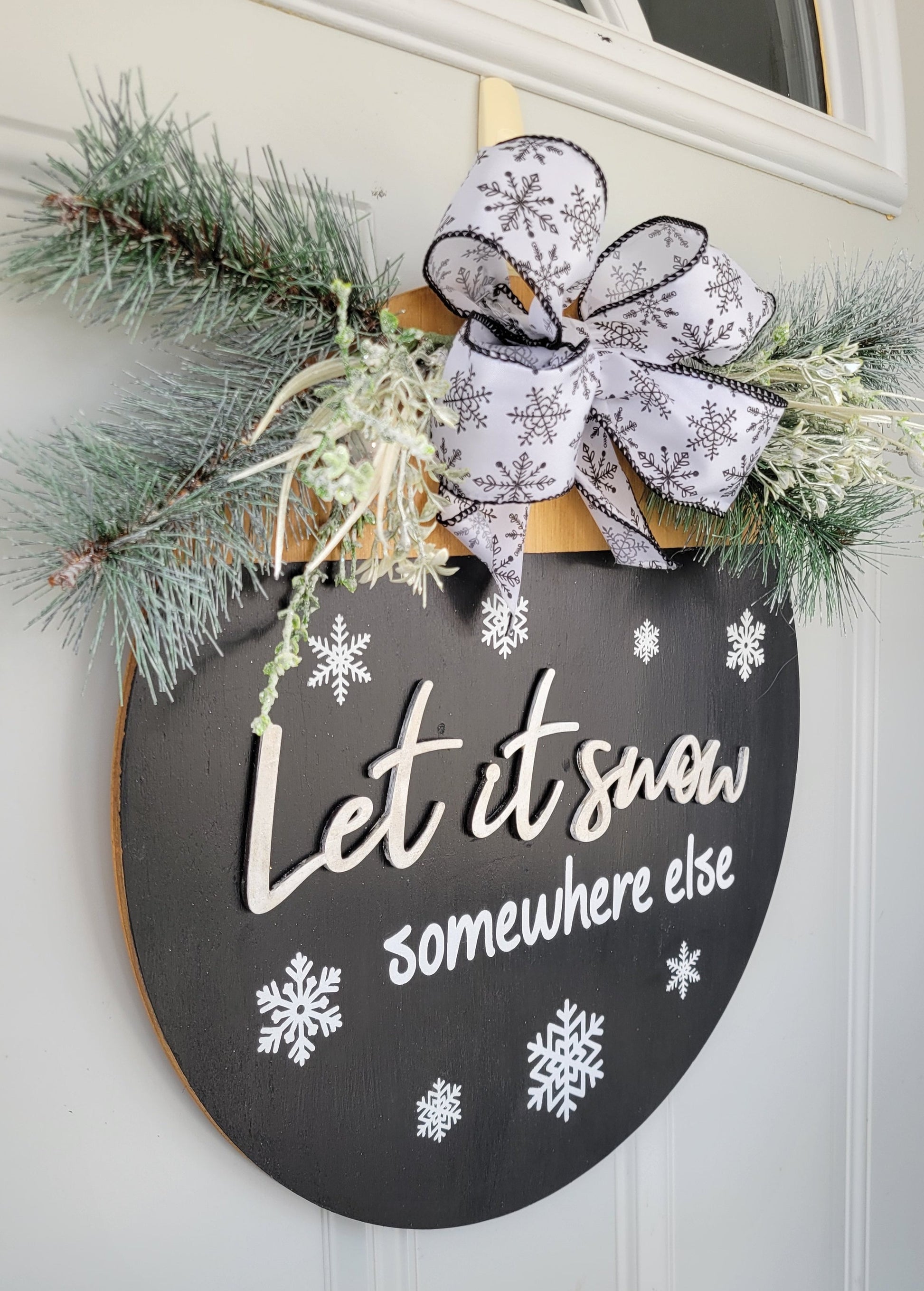 black and white Let it snow somewhere else door hanger with snowflake ribbon and pine tree greenery