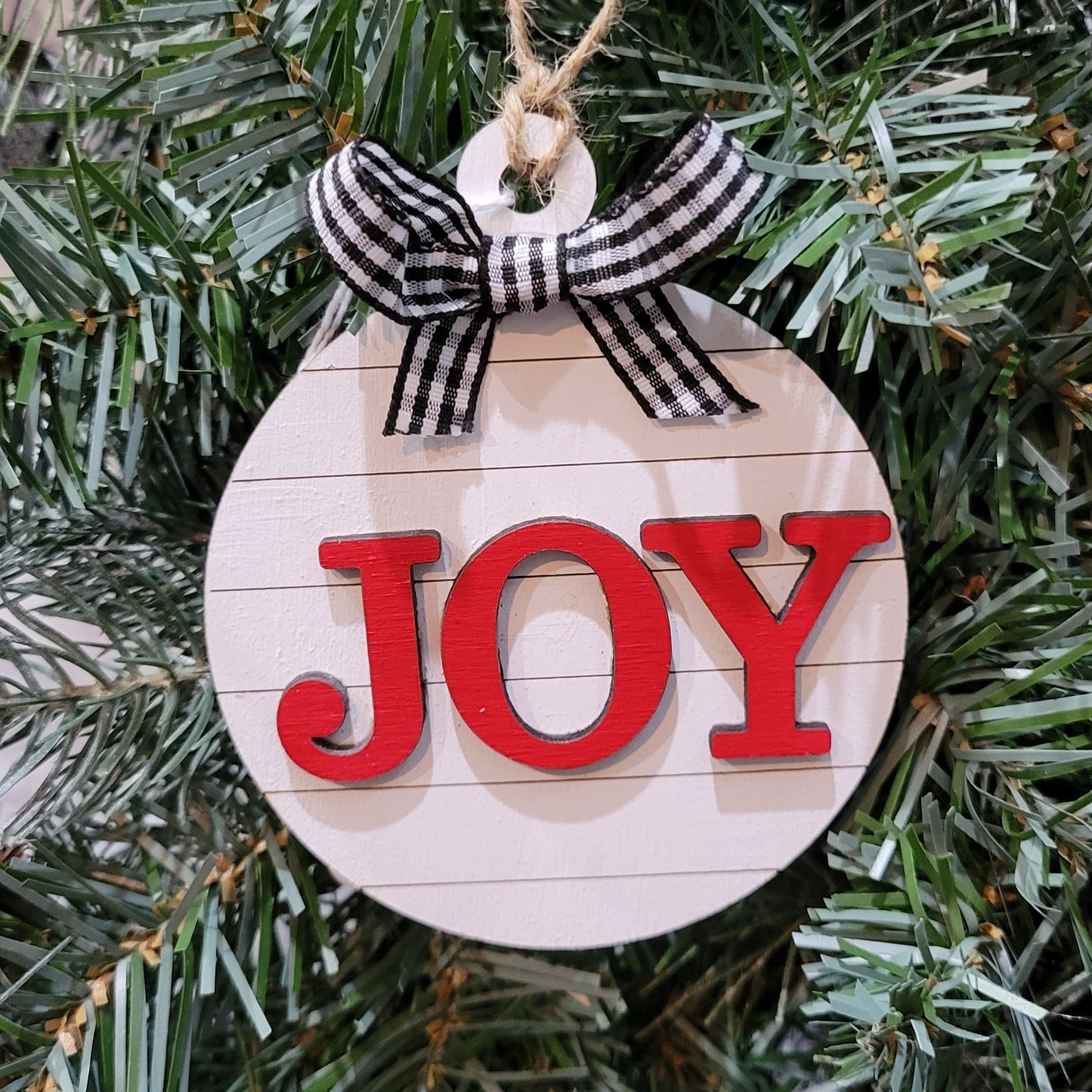 round white shiplap look striped christmas ornament with the word joy