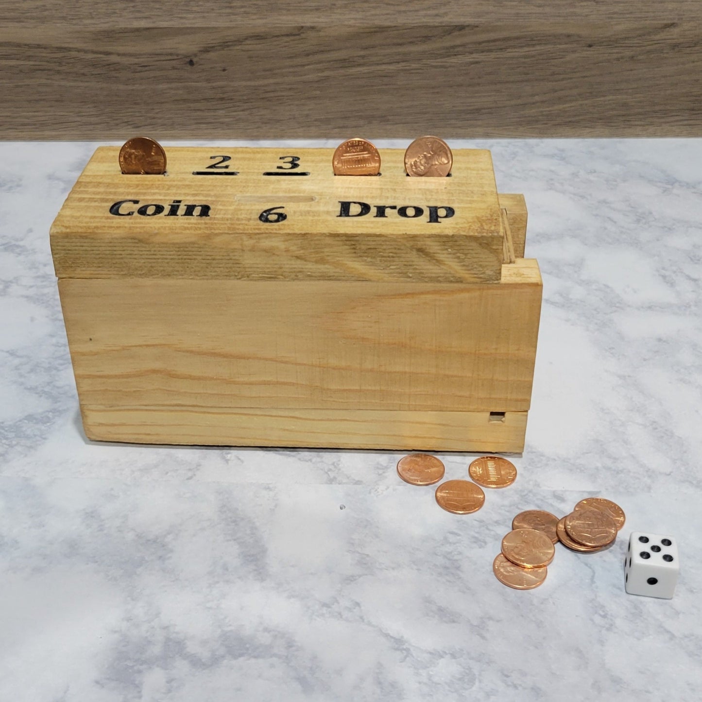 handmade wood coin drop game in play with coins