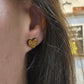 engraved golden oak cheetah print heart-shaped stud earrings on ears